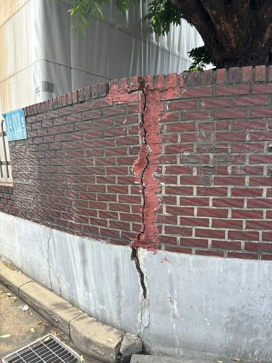 벽돌담장에 생긴 수직 균열과 벌어진 줄눈 상태