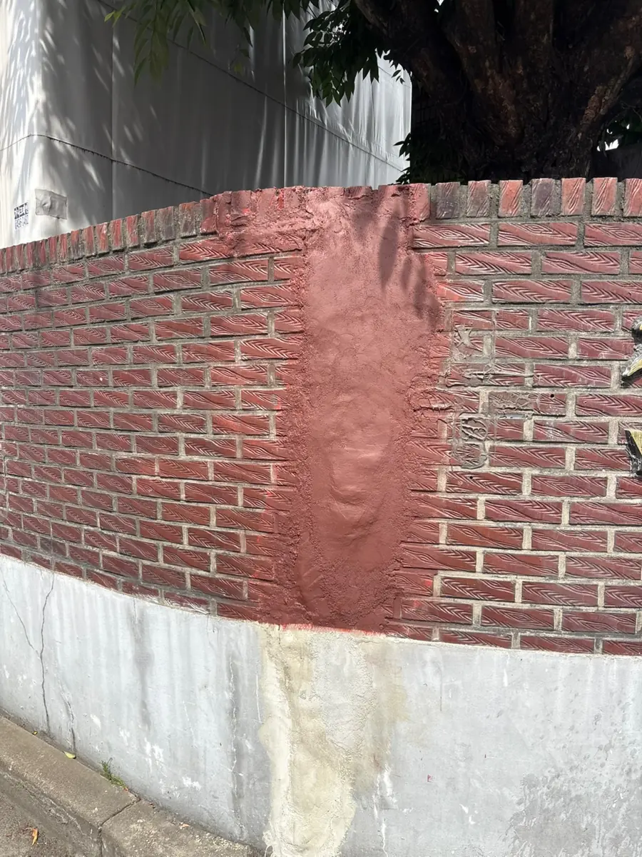 벽돌담장 보수 부위 도색 후 주변 벽돌과 이어진 모습